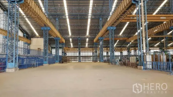 Factory for rent in Mueang Samut Sakhon, Samut Sakhon - Spacious factory bay featuring overhead crane girders, bright lighting, and clear floor area.