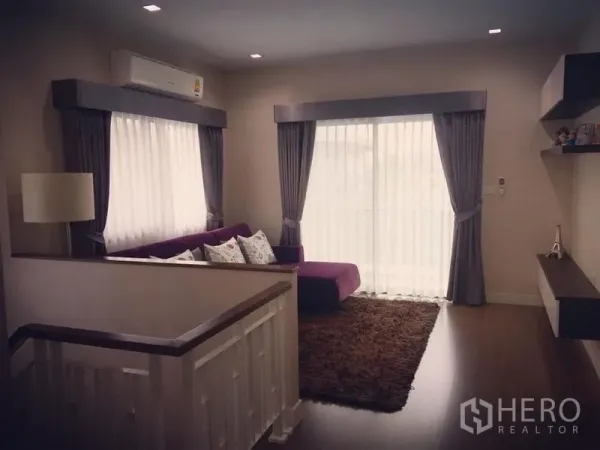 Detached House for sale - Upper-floor lounge with wood flooring and balcony doors framed by curtains.