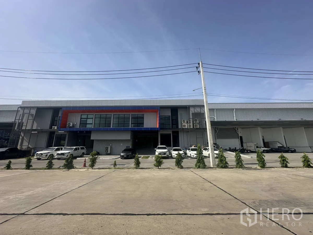 货栈 出租在Khlong Luang, Pathum Thani - 仓库正立面，中央办公室、停放车辆与绿化带