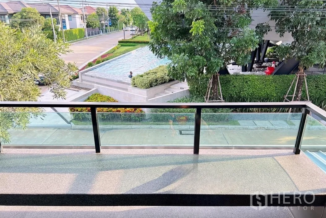Detached House for rent or sale in Lam Luk Ka, Pathum Thani - Balcony view overlooking the community pool and greenery.