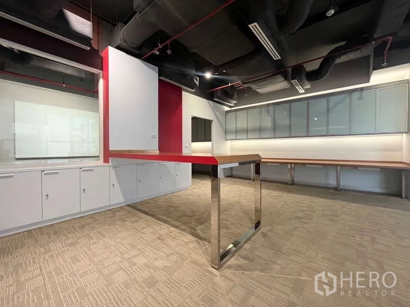 Office Space for rent in Watthana, Bangkok - Central collaboration island with white storage cabinets and track lighting.