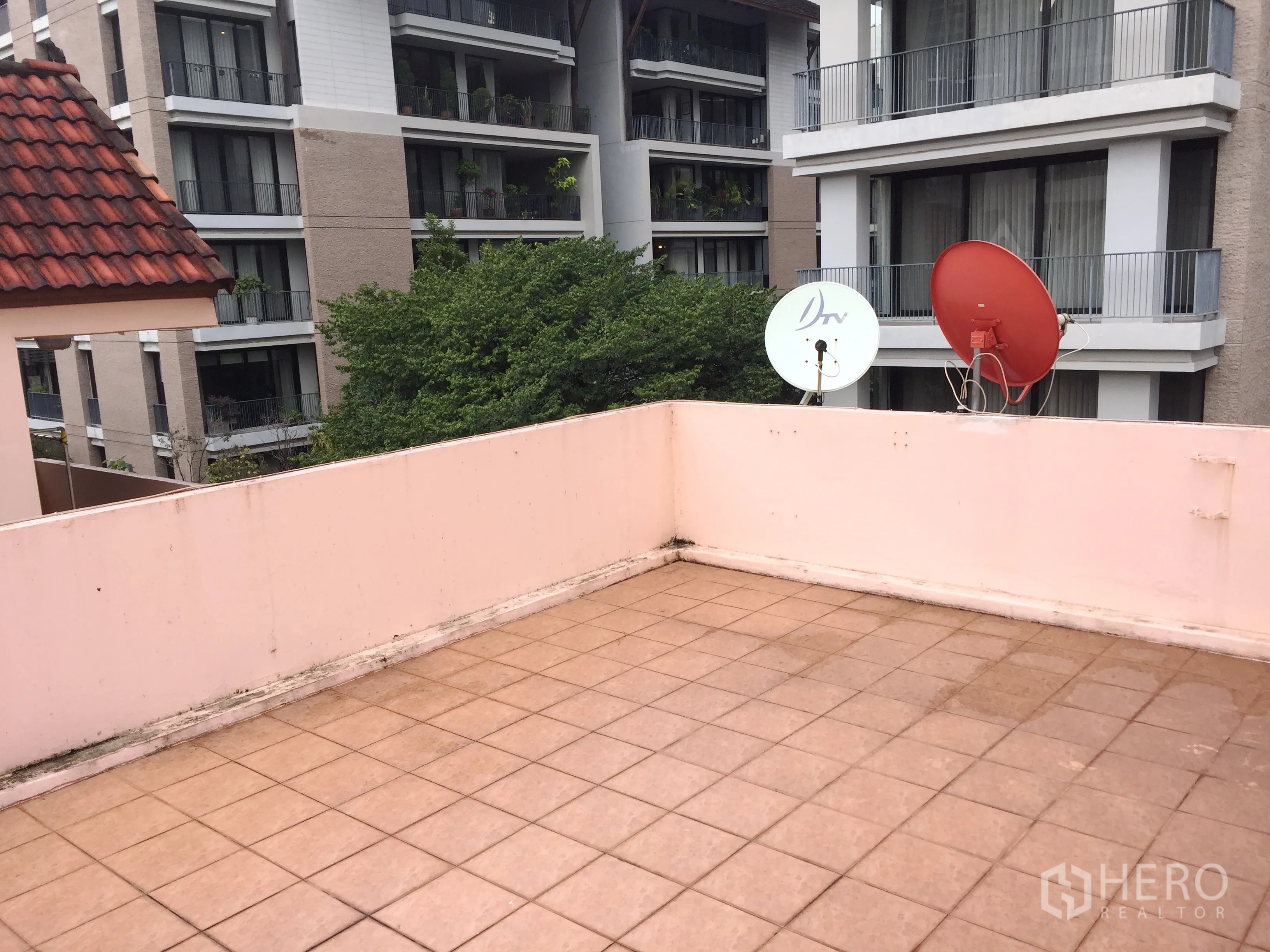 Detached House for rent in Watthana, Bangkok - Tiled rooftop terrace with satellite dishes and views of nearby buildings.