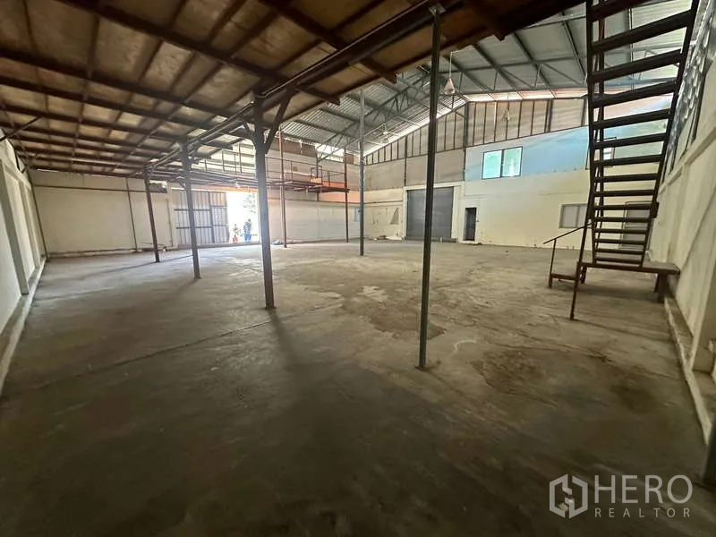 货栈 出租在Suan Luang, Bangkok - 仓库侧视角，开放地坪与通往夹层的楼梯。