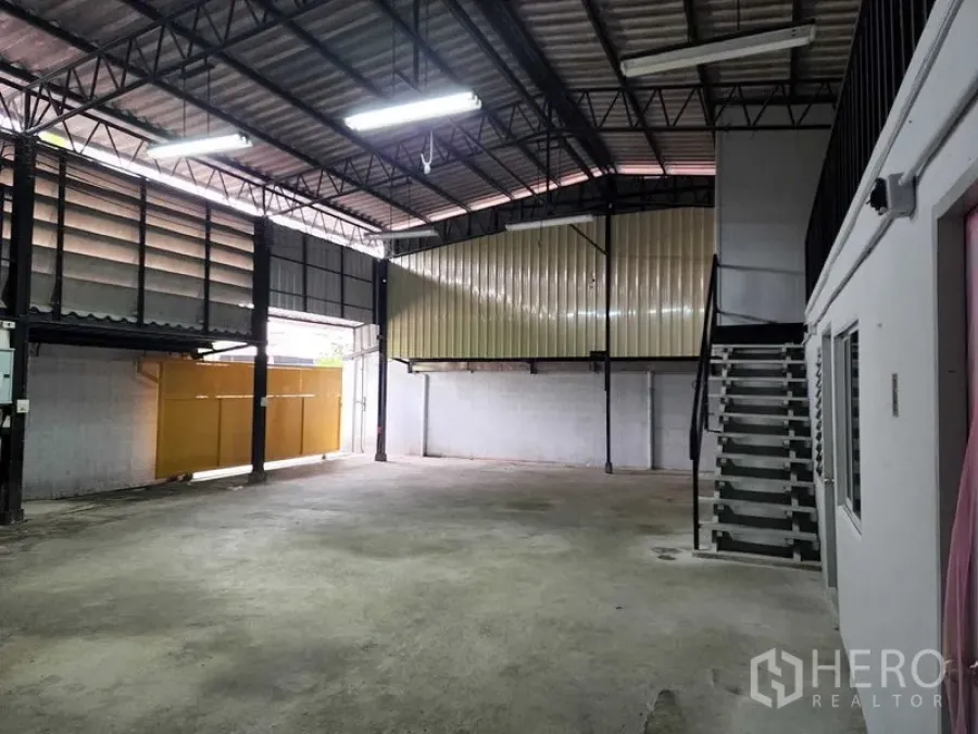 Warehouse for rent in Chatuchak, Bangkok - Clear loading space facing metal entry gate and raised side platform with stairs.