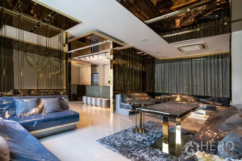 Townhouse for rent in Bang Phli, Samut Prakan - Luxury living lounge with gold details, mirrored ceiling, marble table and plush seating.