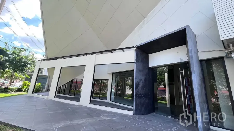 Retail Space for rent in Khlong Toei, Bangkok - Glass entrance with double doors and wide storefront windows facing a paved forecourt.