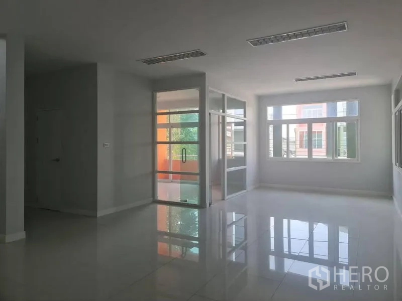 Factory for rent or sale in Lam Luk Ka, Pathum Thani - Open-plan office area with glass meeting rooms and wide windows for natural light.