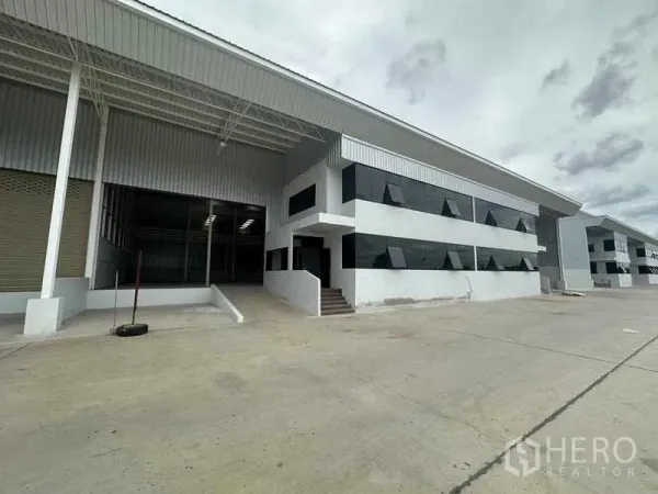 Factory for rent in Wang Noi, Phra Nakhon Si Ayutthaya - Angled view of the warehouse entrance, stairs to office block, and large yard.