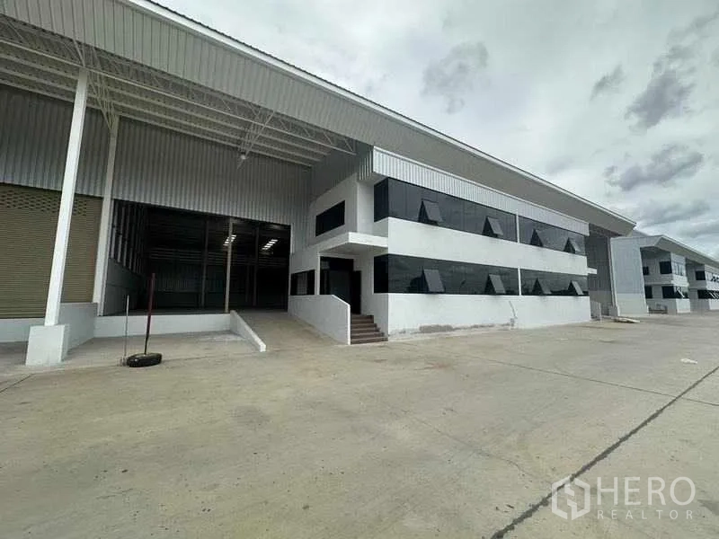 Factory for rent in Wang Noi, Phra Nakhon Si Ayutthaya - Angled view of the warehouse entrance, stairs to office block, and large yard.