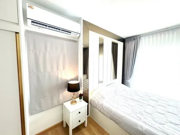 Detached House for rent - Cozy bedroom with window drapes, bedside table and wall-mounted air conditioner.