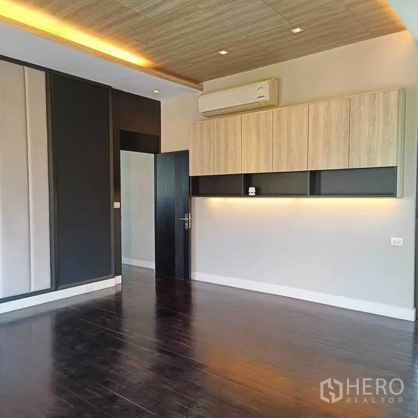 Detached House for rent or sale in Mueang Nonthaburi, Nonthaburi - Bright bedroom with dark wood floors, built-in cabinets and feature ceiling lighting.