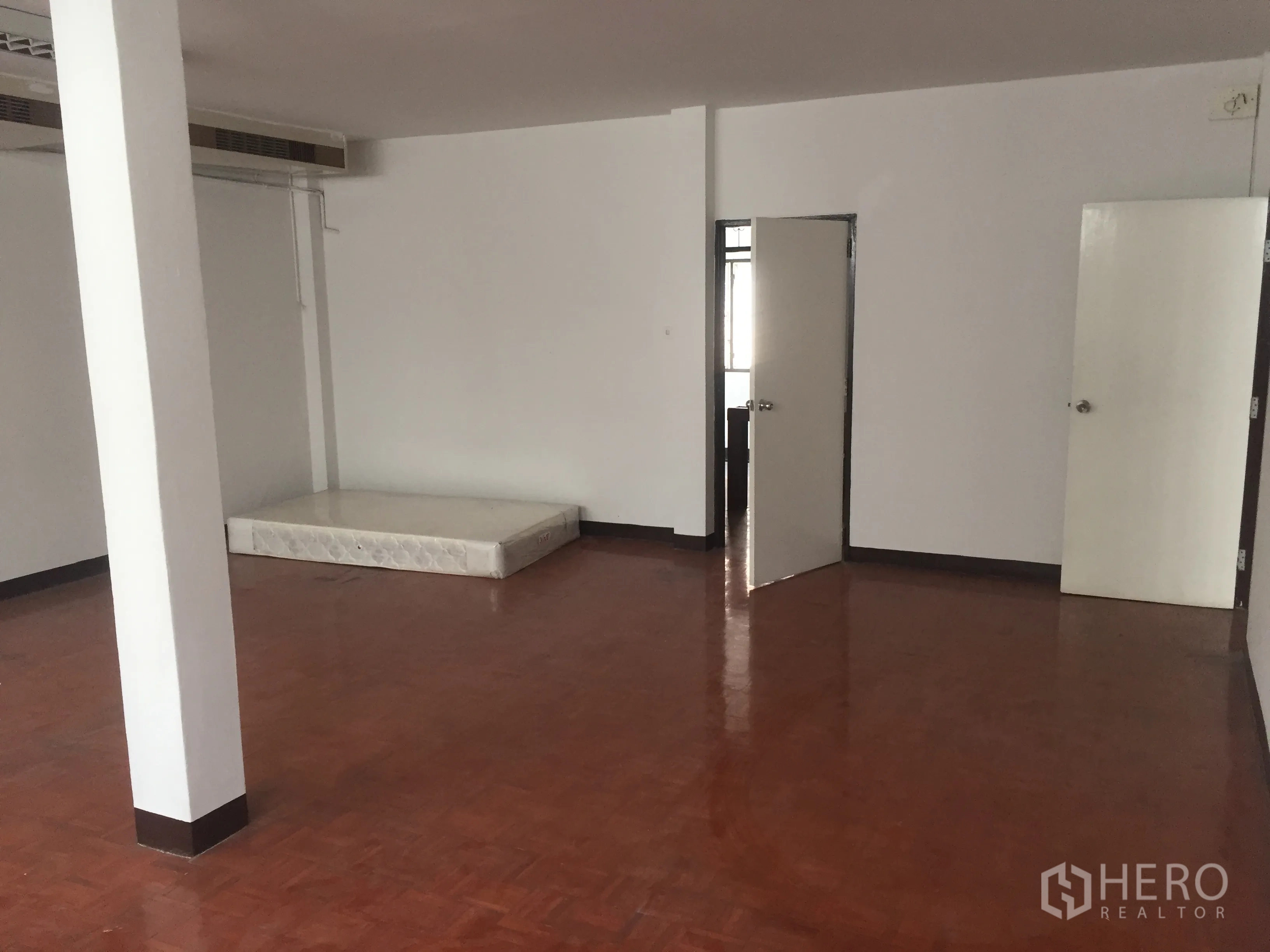 Home Office for rent in Watthana, Bangkok - Large room with polished parquet floor and two interior doors suitable for private offices or bedrooms.