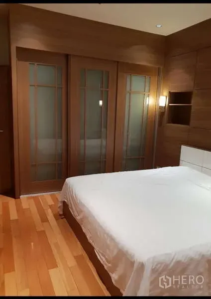Condominium for rent - Warm bedroom with wooden built-ins, sliding wardrobes, queen bed and timber flooring.