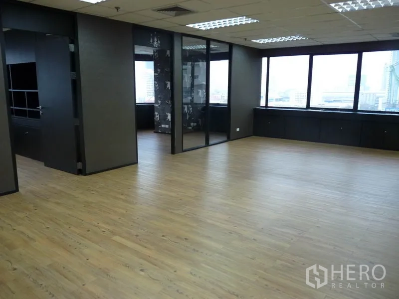 Office Space for rent in Watthana, Bangkok - Open-plan workspace with wood flooring, a glass-partitioned meeting room and large windows with city views.