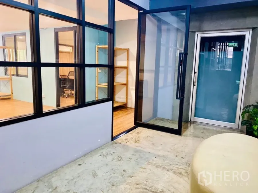 Office Space for rent in Bang Rak, Bangkok - Shared corridor with large glass doors opening into the office.