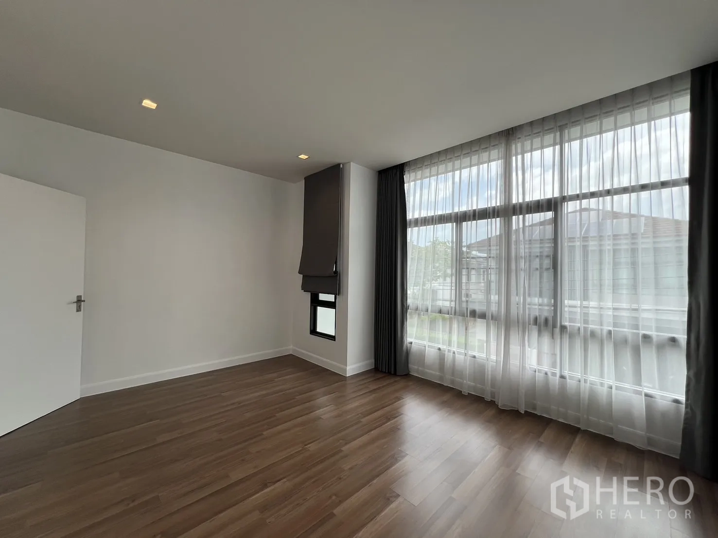 Detached House for rent in Bang Kapi, Bangkok - Second bedroom view highlighting large windows and wood floors.