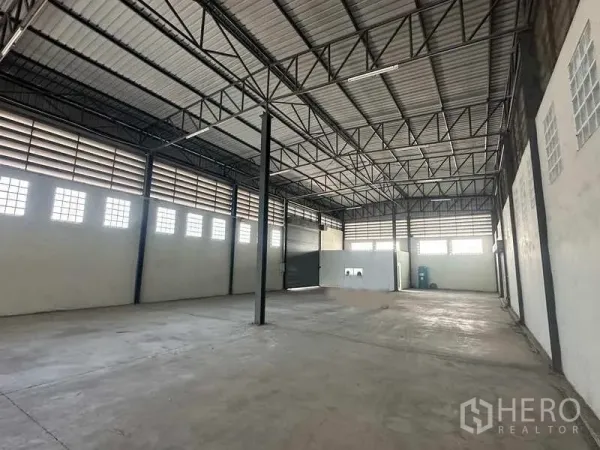 Warehouse for rent in Bang Bua Thong, Nonthaburi - Large warehouse interior with multiple shutters and smooth concrete floor