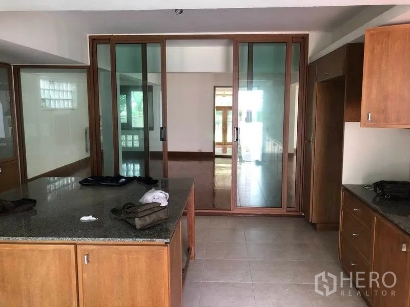 Detached House for rent in Watthana, Bangkok - Spacious kitchen with granite island and glass sliding doors.