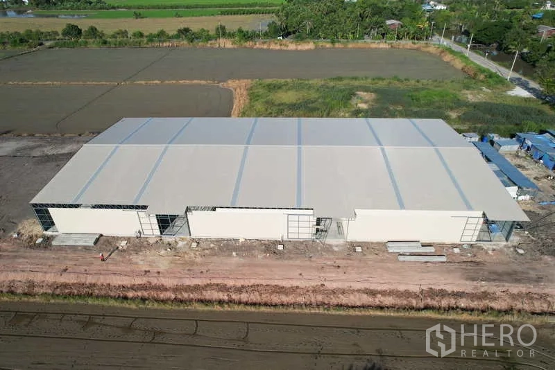 Warehouse for rent or sale in Pak Kret, Nonthaburi - Aerial view of the new warehouse complex surrounded by fields with a front access road.