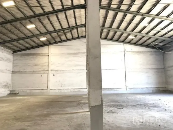Warehouse for rent in Lat Krabang, Bangkok - Open storage bay inside the warehouse showing the metal roof, smooth concrete slab, white perimeter walls and a structural column.