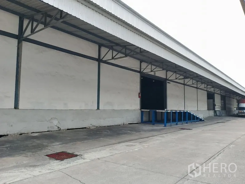 Warehouse for rent in Bang Phli, Samut Prakan - Long warehouse facade with canopied loading area and truck access lane.