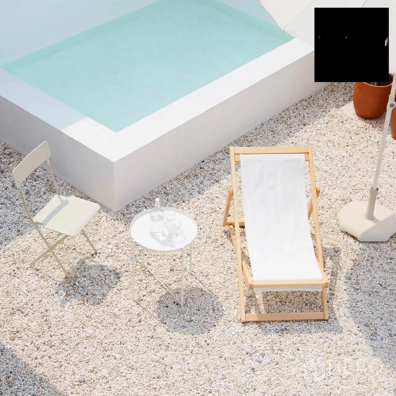Shophouse for rent in Phra Khanong, Bangkok - Minimalist outdoor patio with a small square plunge pool, sun lounger, side table, and umbrella on gravel.