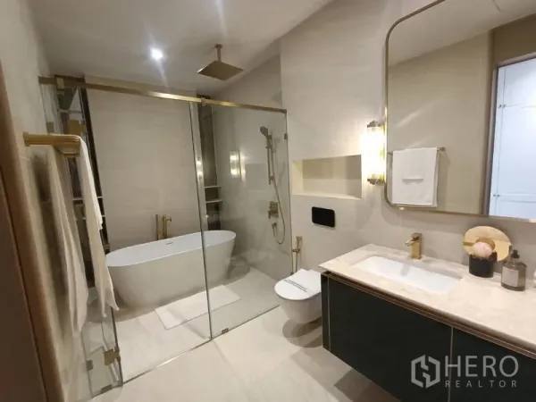 Detached House for sale - Modern bathroom with glass shower, freestanding tub and marble vanity with brass fixtures.