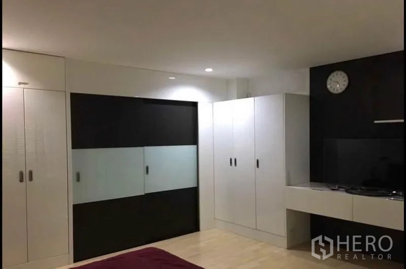 Townhouse for sale in Khlong Toei, Bangkok - Spacious bedroom with large built-in wardrobes and sliding glass closet doors.