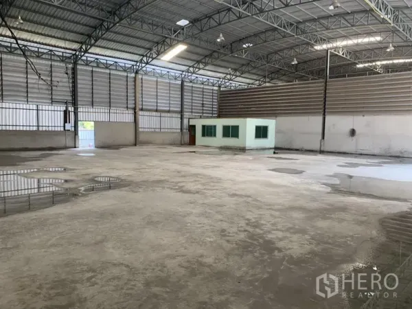 Warehouse for rent in Bueng Kum, Bangkok - Spacious warehouse interior featuring a high steel-truss roof, concrete floor and a built-in office room.