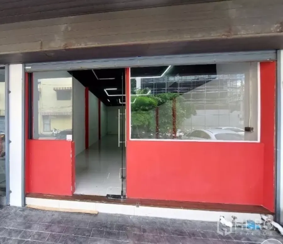 Retail Space for rent in Khlong Toei, Bangkok - Street-level retail frontage with large glass display windows, red panels and a clear glass door.