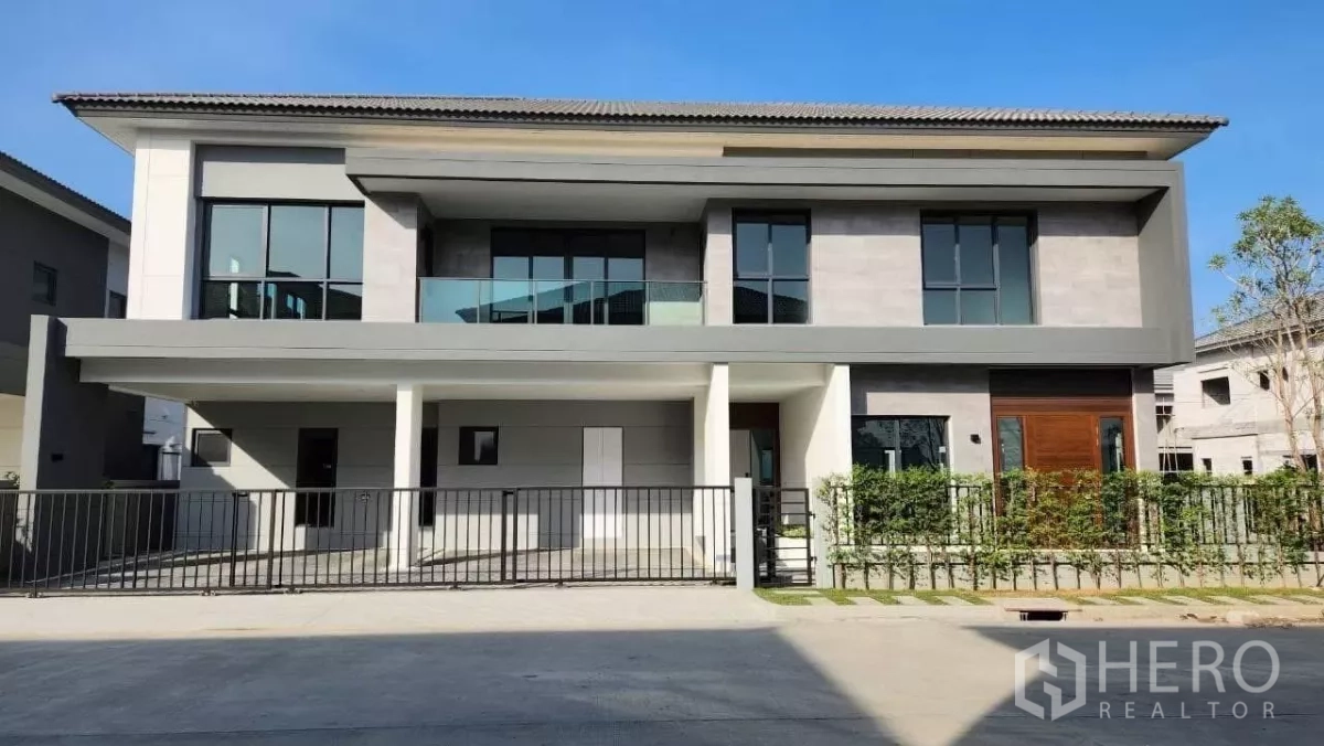 Detached House for rent or sale in Bang Phli, Samut Prakan - Modern two‑storey detached house with wide frontage, balcony, large windows, and gated driveway on a corner plot.