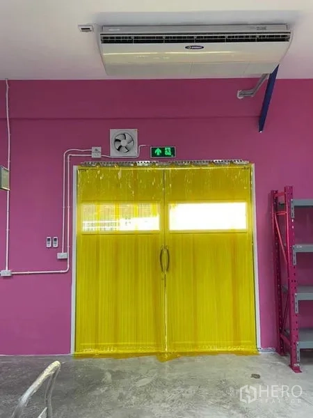 Warehouse for rent in Khlong Luang, Pathum Thani - Loading doorway with yellow PVC strip curtains and ceiling-mounted air conditioner.