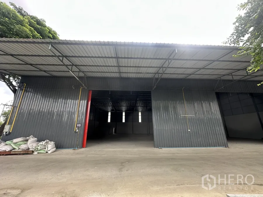 货栈 出租在Lam Luk Ka, Pathum Thani - 全新金属外墙仓库外观，超宽卷帘门与宽阔混凝土装卸场地。