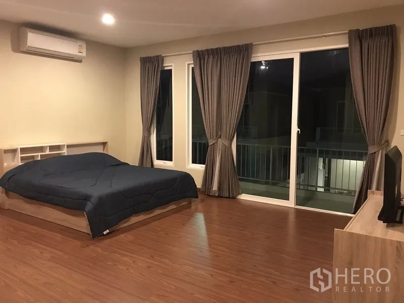 Detached House for rent or sale in Bang Na, Bangkok - Spacious master bedroom with wood floors, large windows and sliding doors to the balcony.