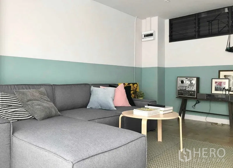 Townhouse for rent or sale in Khlong Toei, Bangkok - Cozy lounge with sectional sofa, round coffee table and mint‑white two‑tone walls.