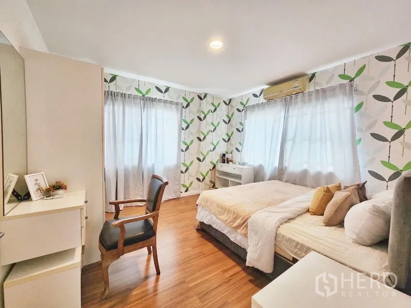 Detached House for rent in Prawet, Bangkok - Large second bedroom with leafy wallpaper, corner windows and seating area.