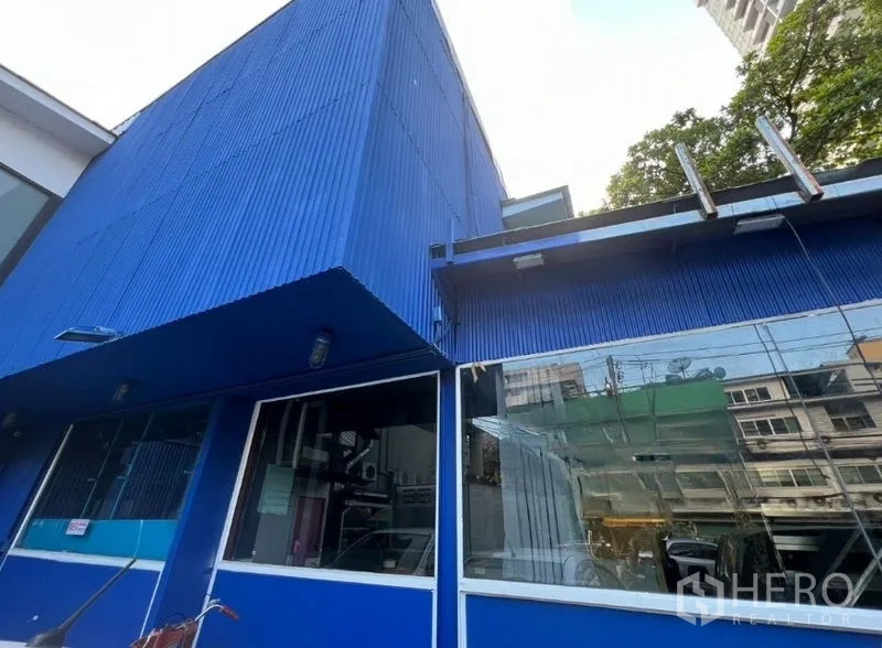 Retail Space for rent in Watthana, Bangkok - Blue retail building exterior with large glass frontage and corrugated facade.