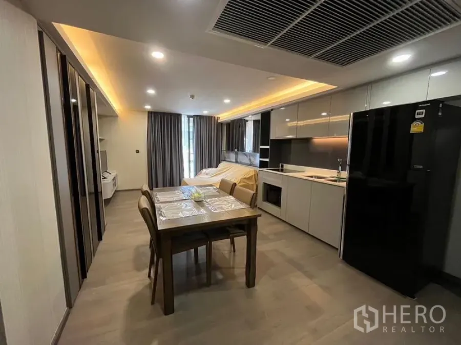 Condominium for rent in Pathum Wan, Bangkok - Open kitchen and dining area with integrated appliances and a large fridge.