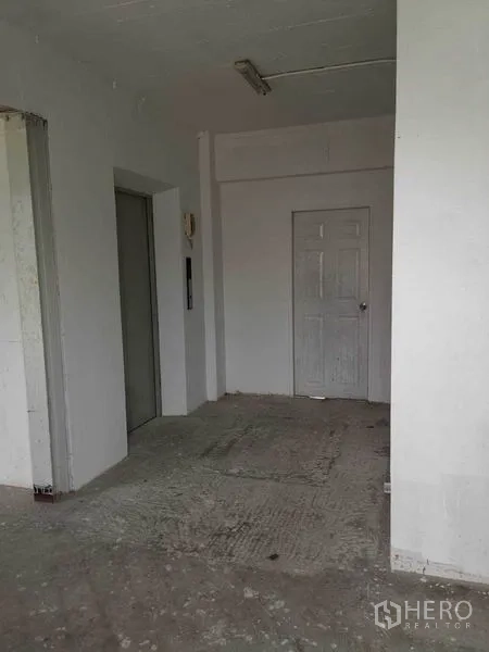 Retail Space for rent in Watthana, Bangkok - Unfinished retail lobby with elevator, white walls and concrete flooring.