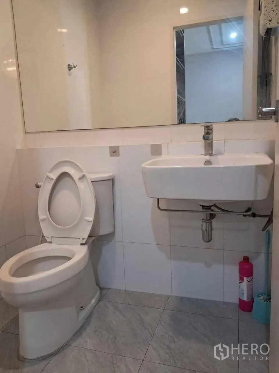 Townhouse for rent in Bang Kapi, Bangkok - Guest bathroom with toilet, sink and a wide mirror.