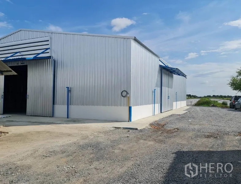 Warehouse for rent in Nong Chok, Bangkok - Metal-clad warehouse exterior with wide sliding doors and gravel yard in Nong Chok, Bangkok.