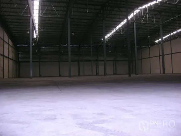 Warehouse for rent in Mueang Samut Sakhon, Samut Sakhon - Spacious warehouse interior with high steel-truss roof, skylight strips and durable concrete floor.