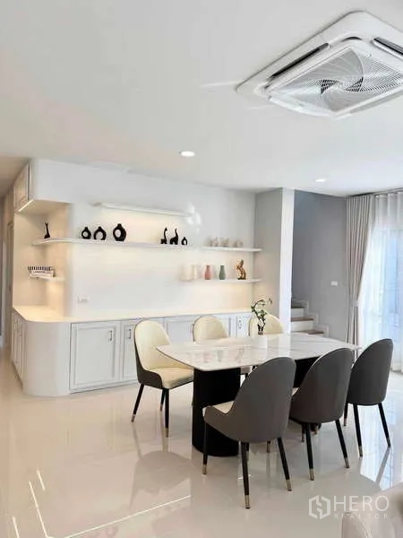 Detached House for rent or sale in Bang Phli, Samut Prakan - Dining area with marble-top table for six, display shelves, recessed lighting and nearby stairs.
