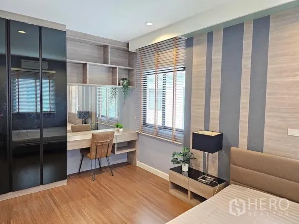 Detached House for rent in Prawet, Bangkok - Bedroom work corner featuring a mirror vanity, open shelves, and a large wardrobe.
