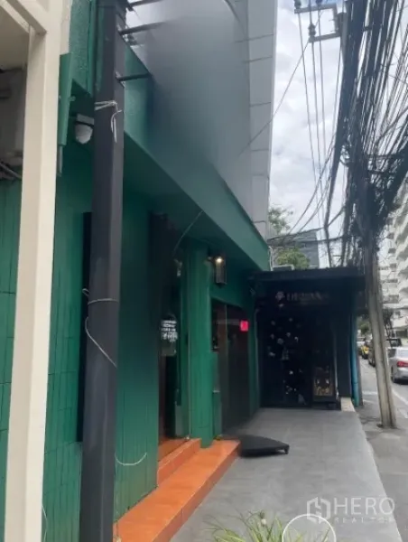 Shophouse for rent in Watthana, Bangkok - Shophouse entrance with awning and steps along a busy Thonglor sidewalk.