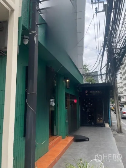 Shophouse for rent in Watthana, Bangkok - Shophouse entrance with awning and steps along a busy Thonglor sidewalk.
