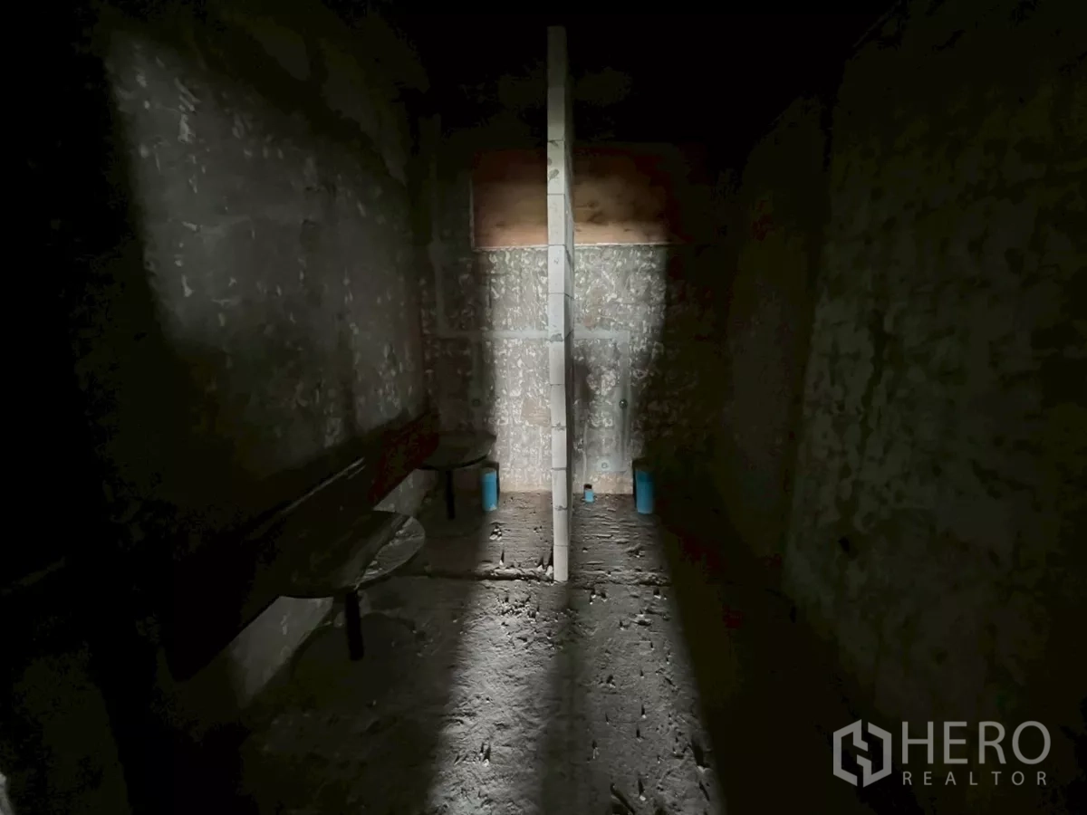 Retail Space for rent in Watthana, Bangkok - Dark unfinished utility room with partition wall and visible plumbing points.