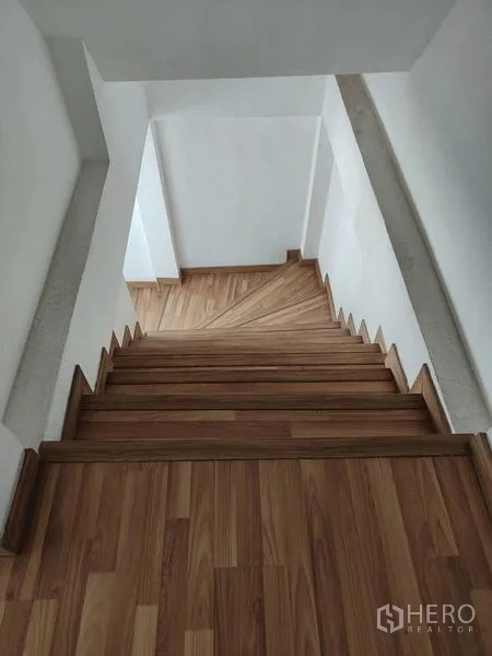 Factory for sale in Sai Noi, Nonthaburi - Interior wooden staircase leading down between office levels.