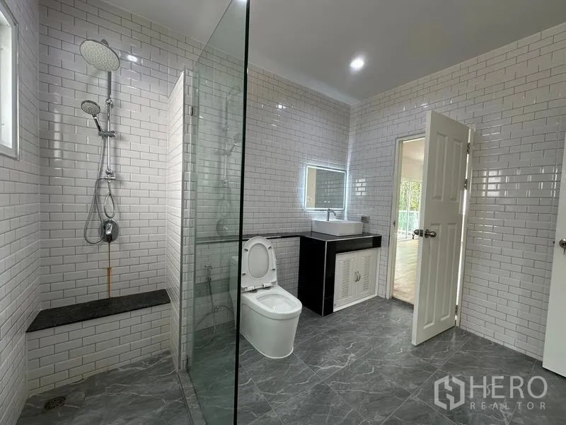 Detached House for sale in Lam Luk Ka, Pathum Thani - Bathroom with white subway tiles, glass shower enclosure and illuminated mirror.