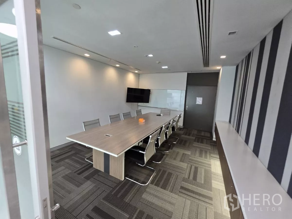 Office Space for rent in Watthana, Bangkok - Mid-size conference room with long table, TV screen and striped feature wall.